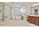A luxurious bathroom boasts a glass enclosed shower, soaking tub, and double sink vanity at 2230 Rim Ridge Dr, Castle Pines, CO 80108