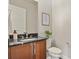 Bathroom features a wood vanity with dark countertops, framed artwork, and a pristine white toilet at 2230 Rim Ridge Dr, Castle Pines, CO 80108