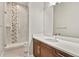 Modern bathroom featuring white countertops, brown cabinets, and a shower with decorative marble-look tile at 2230 Rim Ridge Dr, Castle Pines, CO 80108