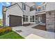 Inviting front entrance with covered porch and modern glass door, complemented by lush landscaping and a well-maintained lawn at 2230 Rim Ridge Dr, Castle Pines, CO 80108