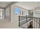Hallway features a staircase with black railings, carpet flooring, and large windows with neighborhood views at 2230 Rim Ridge Dr, Castle Pines, CO 80108