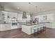 Modern kitchen featuring an island with bar seating, stainless steel appliances, and elegant pendant lighting at 2230 Rim Ridge Dr, Castle Pines, CO 80108