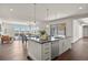 Open concept living area with kitchen island, dining area, and spacious living room featuring bright windows and modern decor at 2230 Rim Ridge Dr, Castle Pines, CO 80108
