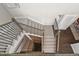 Carpeted staircase with metal railing and hardwood landing at 2230 Rim Ridge Dr, Castle Pines, CO 80108