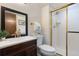 Well-lit bathroom featuring a vanity with a white countertop, a mirror, and a glass-enclosed shower at 3752 S Rosemary Way, Denver, CO 80237