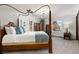 Bedroom featuring a canopy bed, bedside tables, and a dresser near bright windows at 3752 S Rosemary Way, Denver, CO 80237