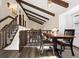 Dining area features exposed beams and a view of the staircase and living room at 3752 S Rosemary Way, Denver, CO 80237