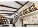 Interior view featuring high vaulted ceilings with exposed beams, a staircase, and a view of the dining area at 3752 S Rosemary Way, Denver, CO 80237