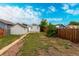 A grassy backyard featuring a detached garage, walkway, and privacy fence; ideal for relaxation and recreation at 436 S 4Th Ave, Brighton, CO 80601