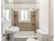 A charming bathroom with a pedestal sink, bathtub with shower, tiled walls, and a window at 436 S 4Th Ave, Brighton, CO 80601