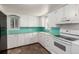 Charming kitchen featuring white cabinets, turquoise backsplash, and windows providing natural light at 436 S 4Th Ave, Brighton, CO 80601