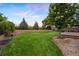 A lush, green backyard features well-maintained landscaping and a charming outdoor deck space at 777 Whispering Oak Dr, Castle Rock, CO 80104