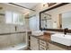 Bathroom with double sink vanity, large mirror, and tiled walk-in shower at 777 Whispering Oak Dr, Castle Rock, CO 80104