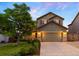 Charming two-story home featuring a well-manicured lawn, lush landscaping, and a spacious two-car garage at 777 Whispering Oak Dr, Castle Rock, CO 80104