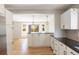Open kitchen with white cabinets, a breakfast bar, hardwood floors, and views into the adjacent living space at 777 Whispering Oak Dr, Castle Rock, CO 80104