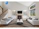 Bright living room with vaulted ceiling, built-in shelving, a fireplace, and large windows providing ample natural light at 777 Whispering Oak Dr, Castle Rock, CO 80104