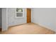 Finished basement area with light wood flooring, whitewashed brick, and an exit door at 14 S Lincoln St # 16, Denver, CO 80209