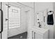 Modern bathroom featuring marble walls, a black hexagon tile floor, and glass block window at 14 S Lincoln St # 16, Denver, CO 80209