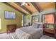 Comfortable bedroom with beamed ceilings and scenic views from multiple windows at 1278 Aspen Dr, Evergreen, CO 80439