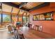Open dining room with exposed wood beams and lovely views of the outdoors at 1278 Aspen Dr, Evergreen, CO 80439