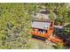 Aerial view of a rustic home with a spacious deck, set amidst lush greenery and natural landscaping at 1278 Aspen Dr, Evergreen, CO 80439