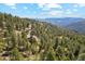 Overhead view of mountain home nestled amongst lush green trees at 1278 Aspen Dr, Evergreen, CO 80439