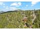 An overhead distant shot of a rural mountain home nestled amongst lush green trees at 1278 Aspen Dr, Evergreen, CO 80439