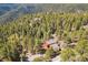 An overhead distant shot of a rural mountain home nestled amongst lush green trees at 1278 Aspen Dr, Evergreen, CO 80439