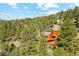 A rustic home with a large wooden deck nestled in a dense forest, offering privacy and scenic views at 1278 Aspen Dr, Evergreen, CO 80439