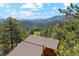 Aerial view showcasing roof and surrounding mountains and trees in the landscape at 1278 Aspen Dr, Evergreen, CO 80439