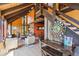 Bright living space features vaulted ceilings, wood beams, a wood stove, and large windows at 1278 Aspen Dr, Evergreen, CO 80439