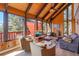 An open concept living room with large windows, vaulted ceilings, and a cozy wood stove at 1278 Aspen Dr, Evergreen, CO 80439