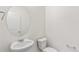 Half bath featuring toilet, sink, mirror, and towel rack at 14269 Beebalm Ave, Parker, CO 80134