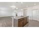Kitchen island featuring a stainless steel dishwasher, sink and dark wood cabinets at 14269 Beebalm Ave, Parker, CO 80134
