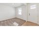 Bright, carpeted living room featuring neutral walls, a window, and a door with glass panels at 14269 Beebalm Ave, Parker, CO 80134