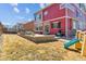 Backyard featuring a stone patio, an outdoor kitchen, well-maintained grass, and some playground equipment at 4736 S Buchanan St, Aurora, CO 80016