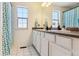 Bright bathroom features a double vanity, mirror, and bathtub with a blue shower curtain at 4736 S Buchanan St, Aurora, CO 80016