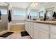 Bright bathroom with double sinks, a bathtub, and a glass-enclosed shower at 4736 S Buchanan St, Aurora, CO 80016