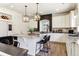 Bright kitchen featuring white cabinets, granite countertops, modern light fixtures, and a kitchen island with seating at 4736 S Buchanan St, Aurora, CO 80016