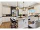 Bright kitchen featuring white cabinets, granite countertops, modern light fixtures, and a kitchen island with seating at 4736 S Buchanan St, Aurora, CO 80016