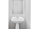 Bathroom featuring a pedestal sink and a frameless mirror at 10065 Martin Luther King Blvd, Denver, CO 80238