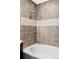 Modern bathroom showcasing a soaking tub with tile surround and rainfall shower head at 10065 Martin Luther King Blvd, Denver, CO 80238