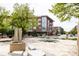 Modern buildings surround a public plaza with stonework and trees, creating a vibrant community space at 10065 Martin Luther King Blvd, Denver, CO 80238