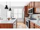 Stylish kitchen features a center island with seating, wood cabinets, and modern stainless appliances at 10065 Martin Luther King Blvd, Denver, CO 80238