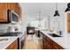 An open-concept kitchen boasts wood cabinets, stainless appliances, and adjacent dining space at 10065 Martin Luther King Blvd, Denver, CO 80238