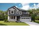 Charming two-story home with gray siding, stone accents, a covered porch, and a two-car garage at 1391 Lumber Ridge N Cir, Erie, CO 80516