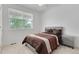 Bedroom with a gray upholstered headboard, patterned bedding, and a window offering natural light at 646 Gamble Oak St, Brighton, CO 80601