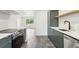 Open-concept kitchen featuring stainless steel appliances, modern gray cabinets, and durable tile flooring at 4467 N Umatilla St, Denver, CO 80211