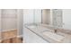 Modern bathroom with double sinks, granite countertop, and a glass-enclosed shower at 7306 Arkansas St, Frederick, CO 80530