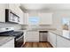 Bright kitchen features granite countertops, stainless steel appliances and wood floor at 7306 Arkansas St, Frederick, CO 80530